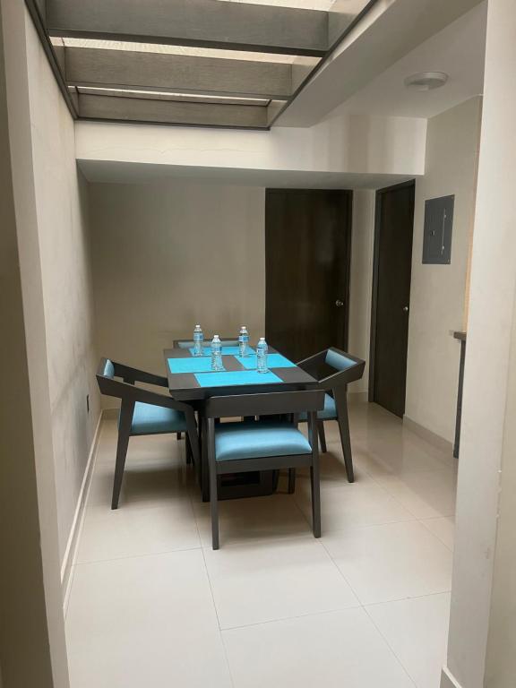 een eetkamer met een tafel en blauwe stoelen bij Suites San Luis in Mazatlán