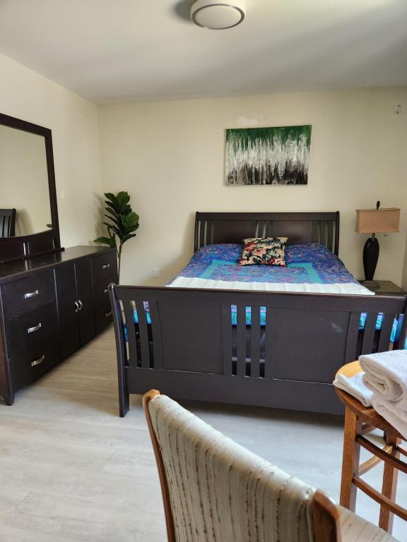 a bedroom with a large bed and a dresser at Elmwood stay in Winnipeg