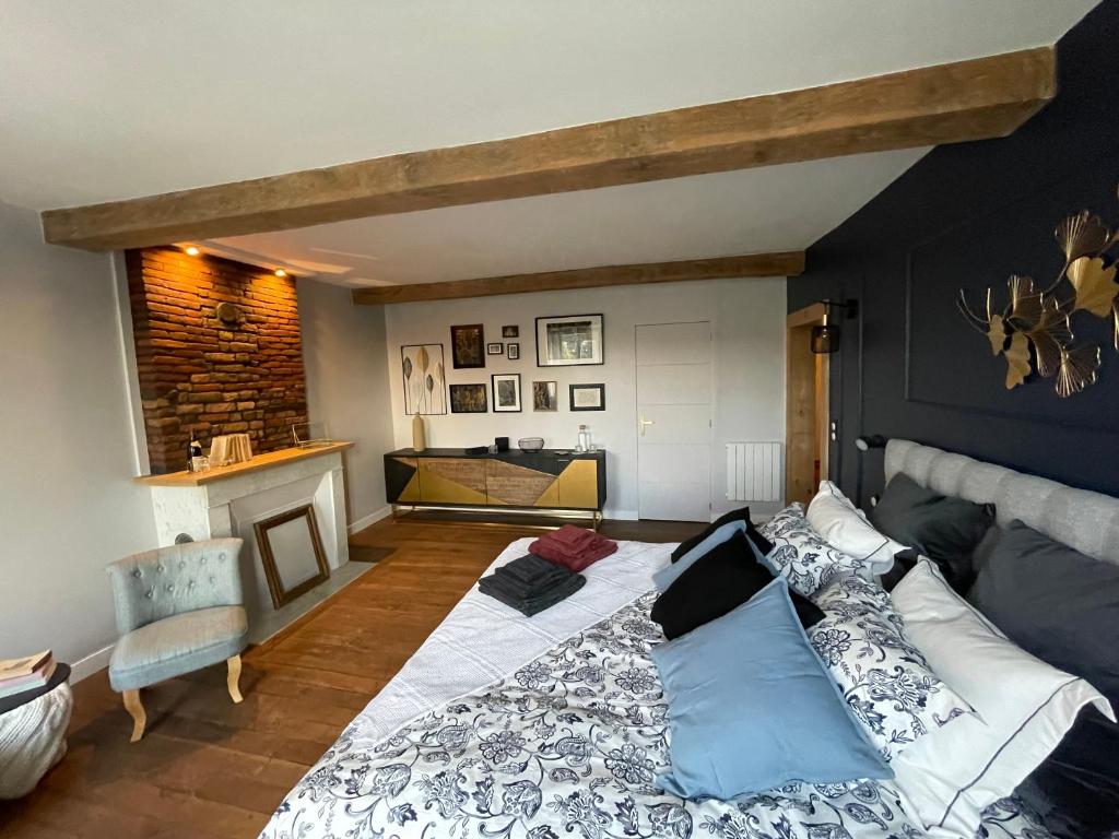 a bedroom with a large bed and a fireplace at Maison Longue de La Cassine in Vendresse