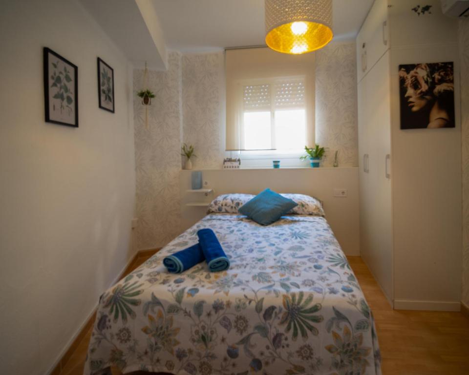 a bedroom with a bed with blue shoes on it at Málaga Casco Histórico in Málaga
