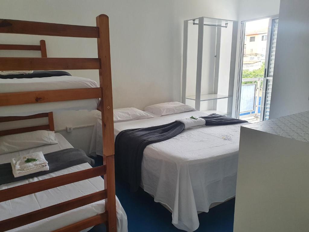 two bunk beds in a room with a window at Hospedaria Dom Pedro - 500m do metrô in Sao Paulo