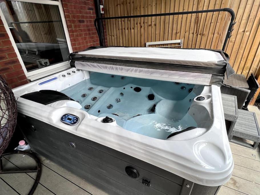 a jacuzzi tub sitting on top of a patio at Thistle House - hot tub, parking in Kent