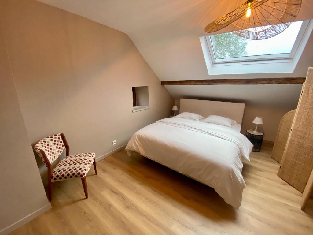 1 dormitorio con cama blanca y ventana en Le Sartisfait en Jalhay