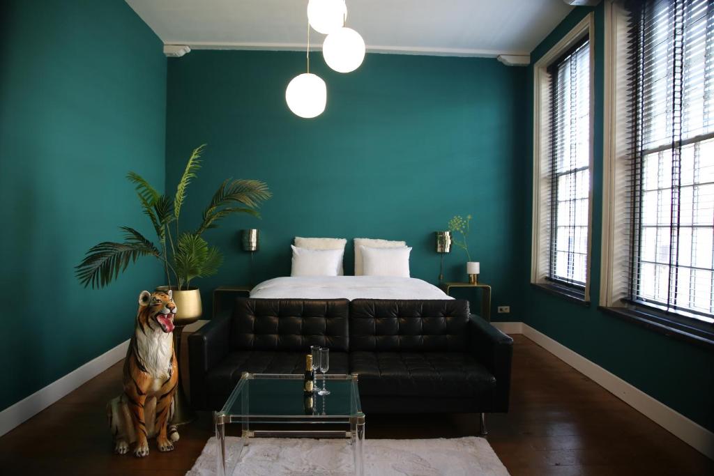 um quarto com uma cama e um sofá de couro preto em Philipse Suite em Nijmegen