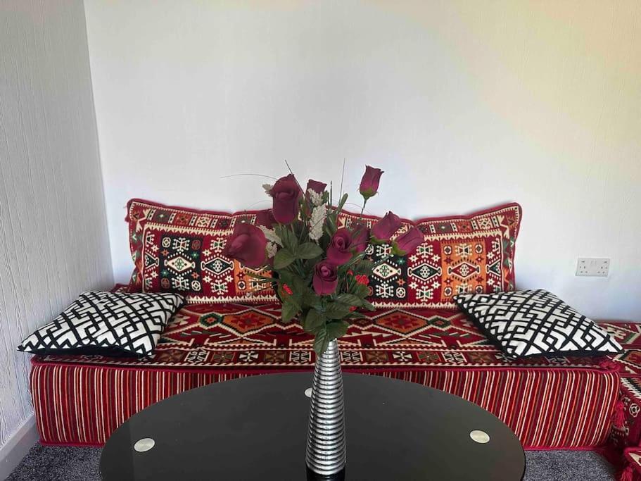 un vaso con fiori su un tavolo di fronte a un letto di Spacious 3 Bed House Near Airport and NEC a Sheldon