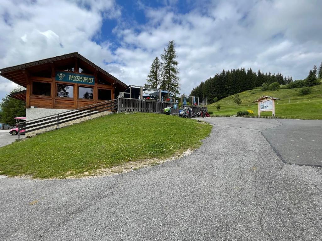 a building with a grassy field in front of it at GESPERE LE STELLA in Les Gets