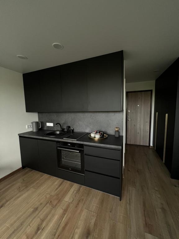 a kitchen with black cabinets and a counter top at 111 Studio Apartment near Old town in Klaipėda