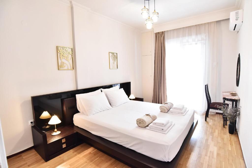 um quarto com uma grande cama branca e uma janela em Downtown Apartment 10 em Kavala