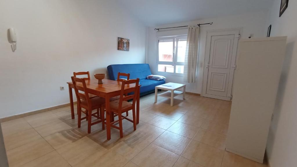 a living room with a table and a blue chair at Vacacional Montañés in El Matorral