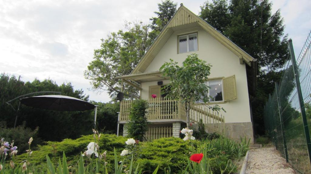 a small house with an umbrella in a garden at Csaford Lodge in Felsőhegy