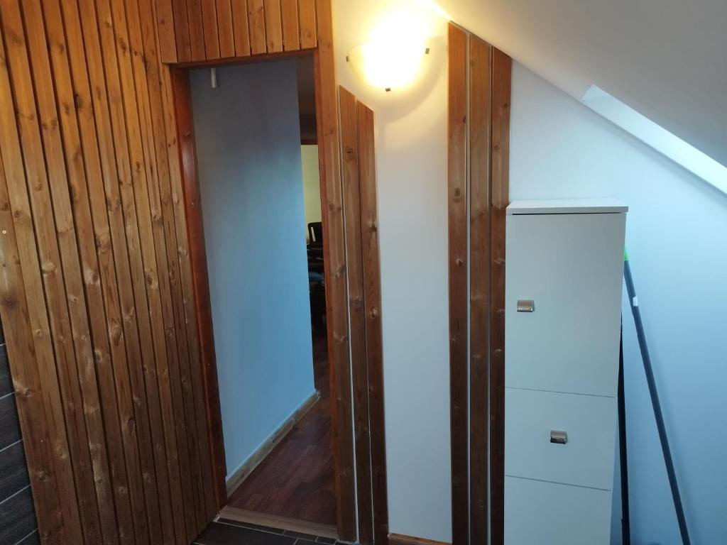 a room with a hallway with a door and a refrigerator at Gabi vendégház in Balatonkeresztúr