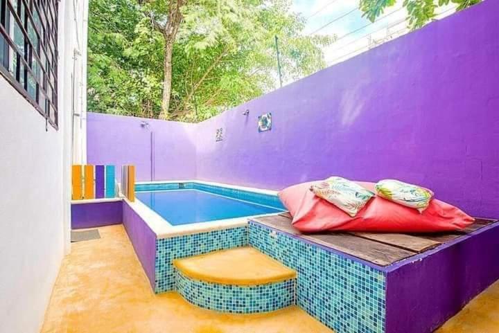 jacuzzi en una habitación púrpura con 2 almohadas en Vainilla Bed and Breakfast Mexico, en Playa del Carmen