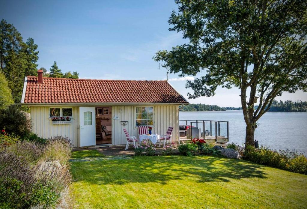a small cottage with a view of the water at Private lakefront property in Söderköping