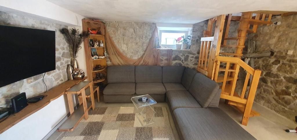 een woonkamer met een bank en een flatscreen-tv bij Villa Thalia in Marinići