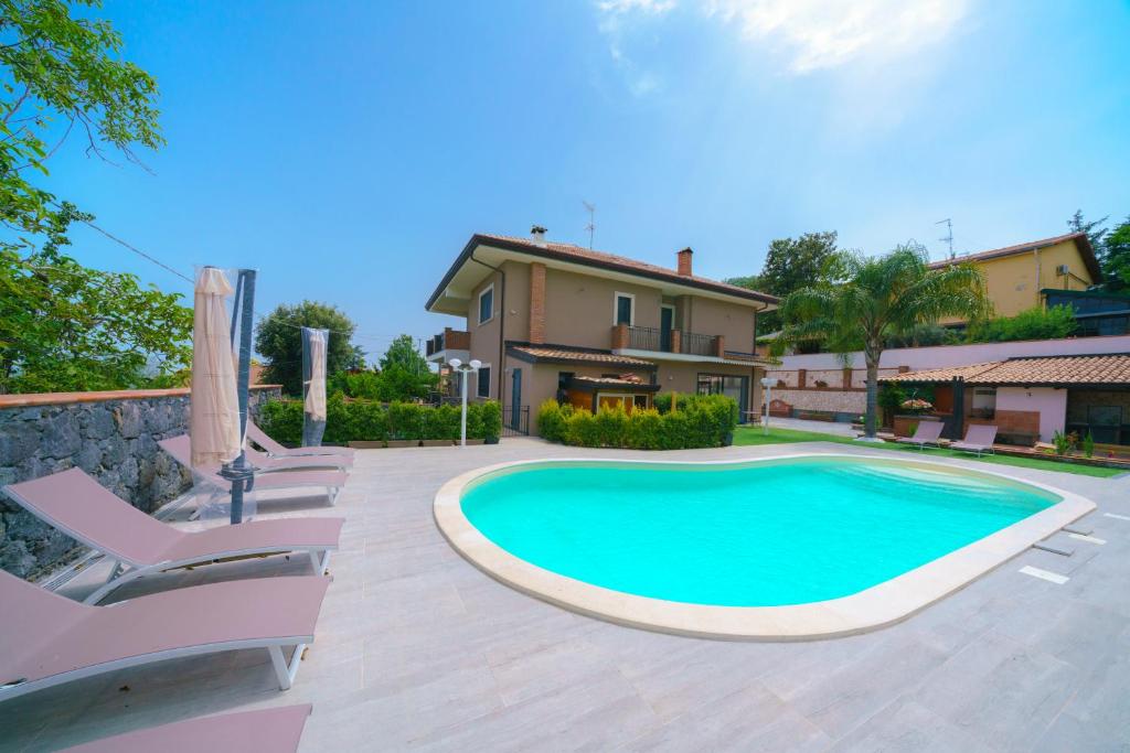 a swimming pool in front of a house at Bedda Mia Etna House B&B in Trecastagni