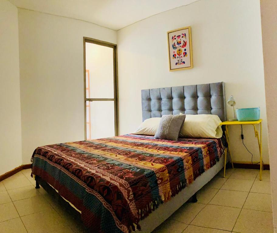 ein Schlafzimmer mit einem Bett mit einer Decke und einem Spiegel in der Unterkunft Full Apartamento en Medellin Itagui Centro de la moda Mayorista Poblado in Itagüí