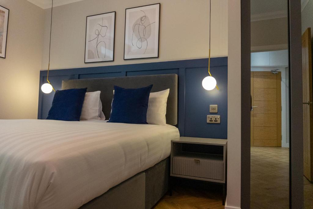 a bedroom with a large bed with blue walls at Oban Apartments in Oban