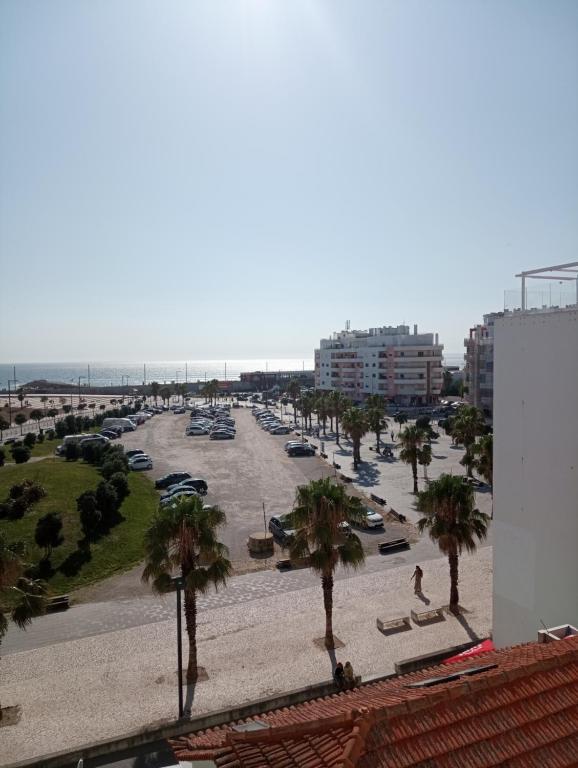 - une vue sur une plage avec des palmiers et un port dans l'établissement Apartamento Costa Azul, à Costa da Caparica