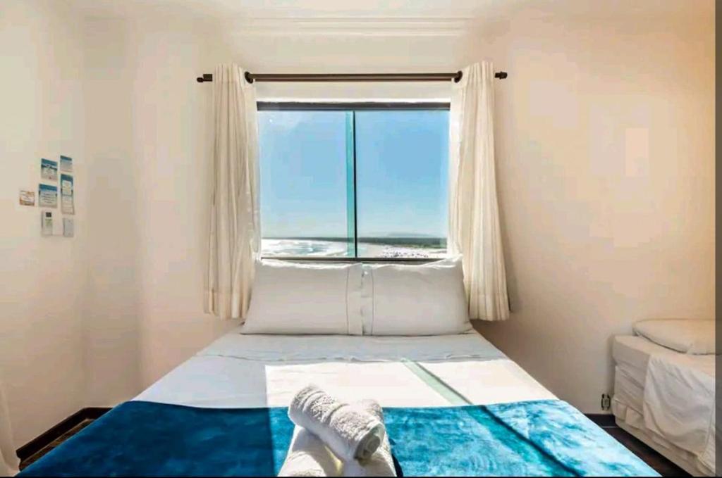 アハイアウ・ド・カボにあるMaré Alta Suítes de Temporada - Seaviewのベッドルーム1室(ベッド1台、大きな窓付)