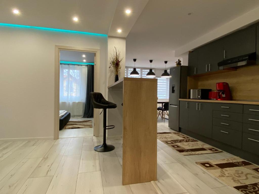 a kitchen with black cabinets and a black stool at Rozalia Apartman in Odorheiu Secuiesc