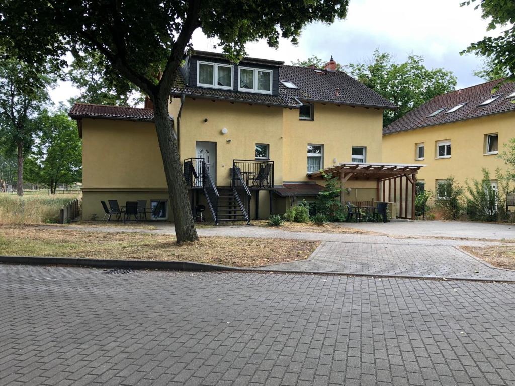 una casa con un árbol delante de ella en FeWo NAHE Berlin für bis zu 8 Monteure, en Mittenwalde