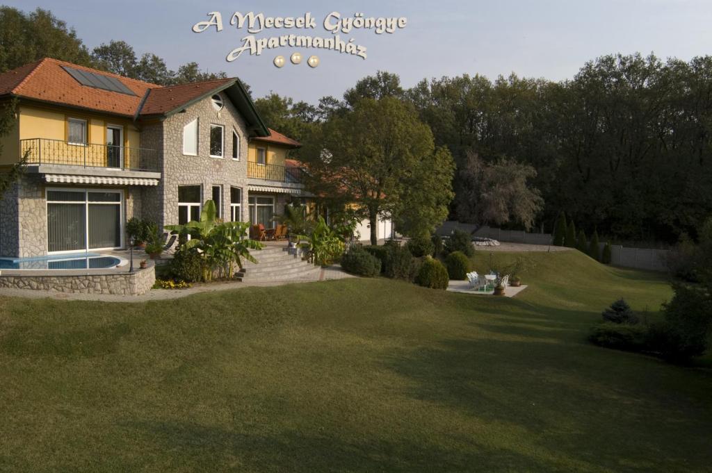 - une vue sur une maison avec une cour verdoyante dans l'établissement A Mecsek Gyöngye Apartmanhaz, à Pécs