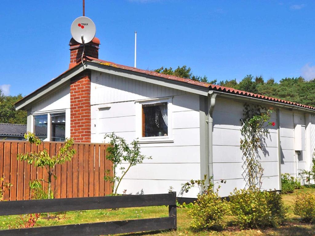une maison blanche avec une cheminée et une clôture dans l'établissement Two-Bedroom Holiday home in Falkenberg 2, à Falkenberg