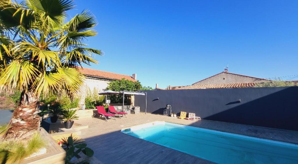 una piscina junto a una casa con una palmera en Studio privé attenant Villa Piscine, en Marsella