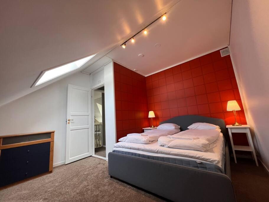 a bedroom with a bed with a red wall at Moldegaard Farmhouse - Apartment C in Moldegard