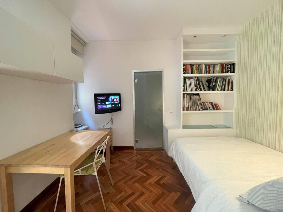 una camera con letto, scrivania e TV di Exclusivo y acogedor Apartamento en Chueca, Madrid a Madrid