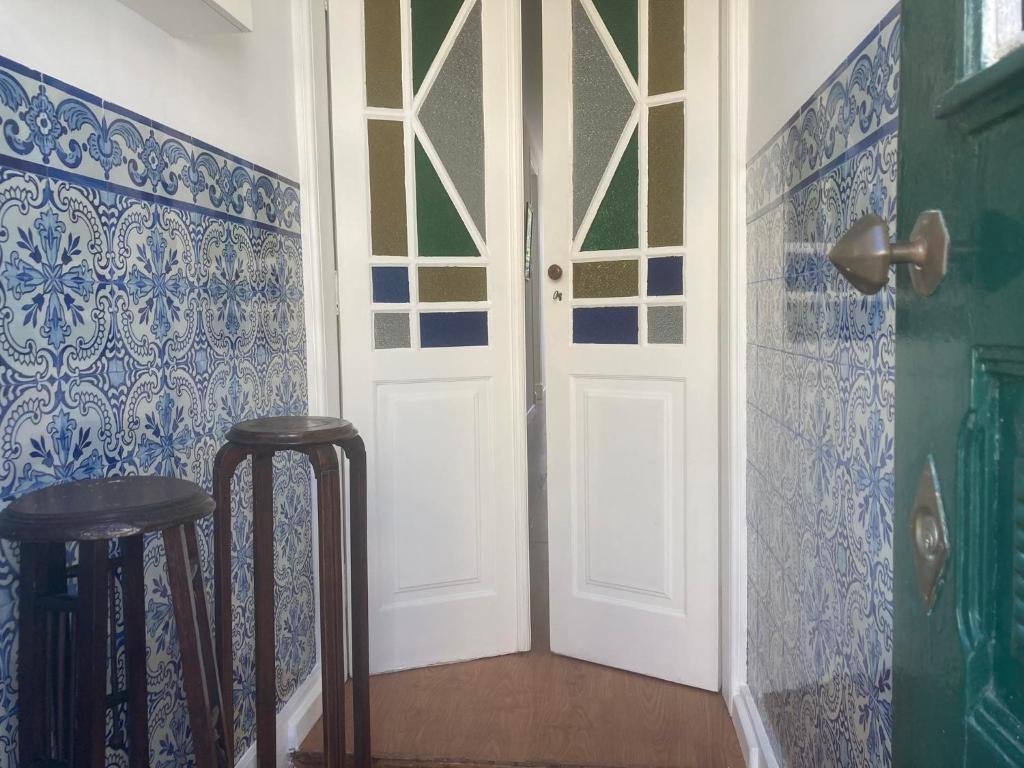 uma sala com dois bancos e uma porta branca em Casa da Genoveva - Typical House em Aveiro