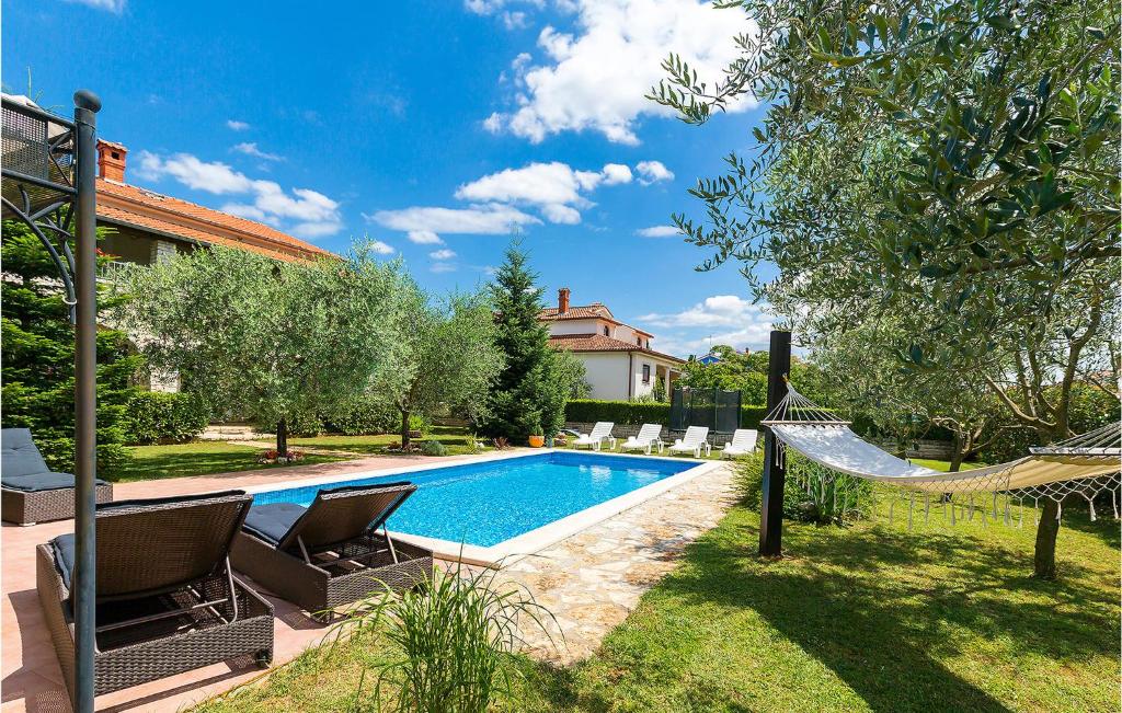 - une piscine avec des chaises et un hamac à côté d'une maison dans l'établissement 4 Bedroom Stunning Home In Zbandaj, à Žbandaj