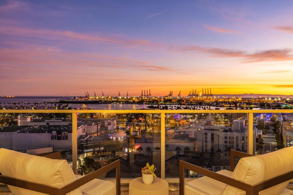 a view of a city from a balcony at sunset at @ Marbella Lane - Penthouse w/ City & Ocean Views in Long Beach