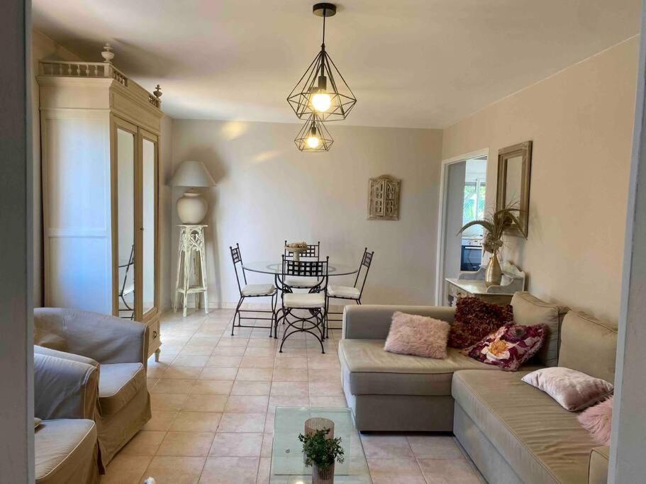 een woonkamer met een bank en een tafel bij Bas de villa T3 sur santa maria di lota in Santa-Maria-di-Lota