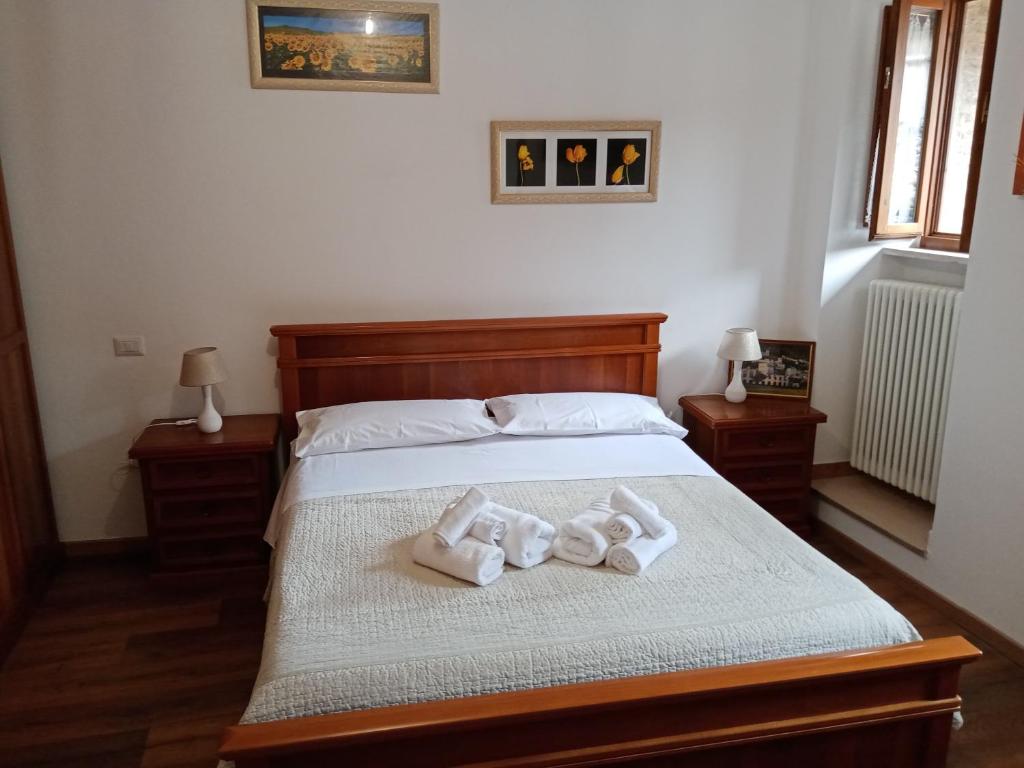 una camera da letto con un letto e asciugamani di La Dimora di Pietra a Gubbio