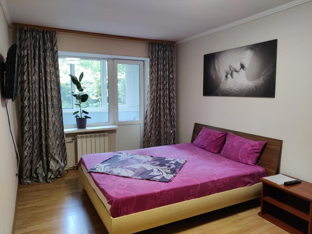 een slaapkamer met een paars bed en een raam bij Apartment on Victora Yarmoly in Kiev