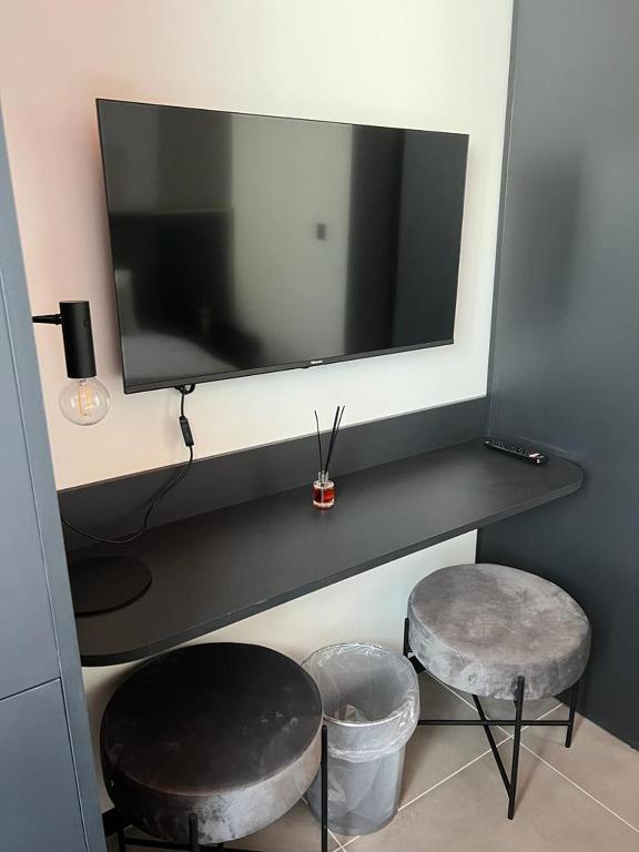 a desk with a tv and two stools in a room at Eleven by Warren Collection in Sliema