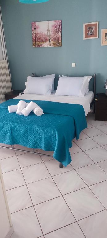 Valantis House في كافالا: غرفة نوم بسريرين وجدار ازرق