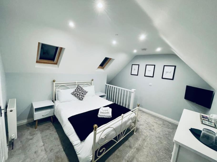 - une chambre avec un lit blanc et un escalier dans l'établissement The Bear Loft, à Chilcompton