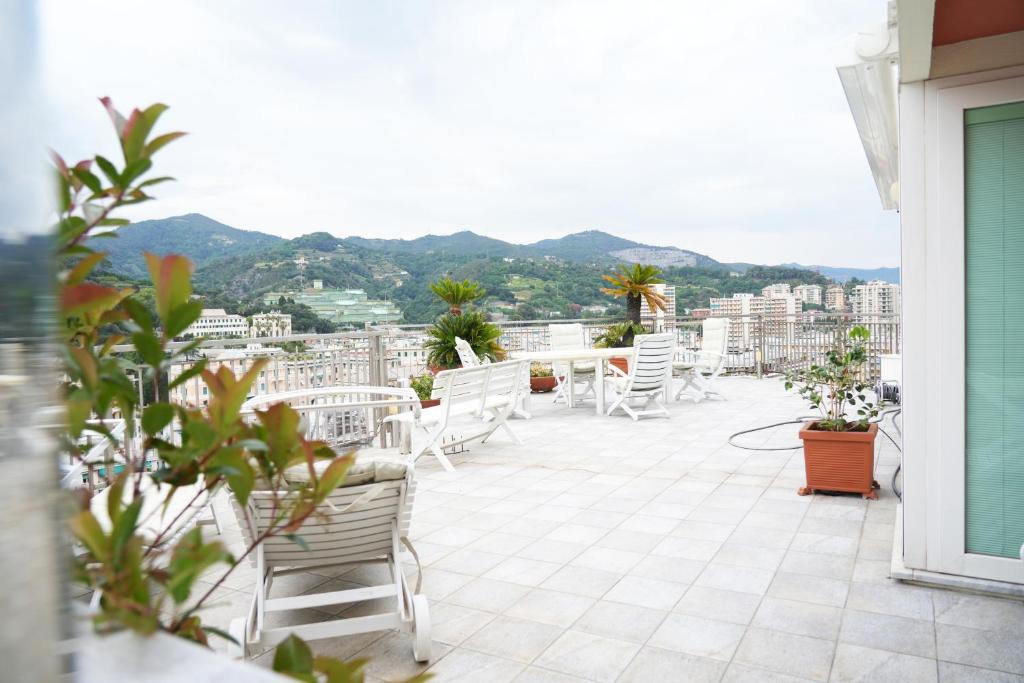 balcone con sedie bianche e vista sulla città di Casa Amina a Genova