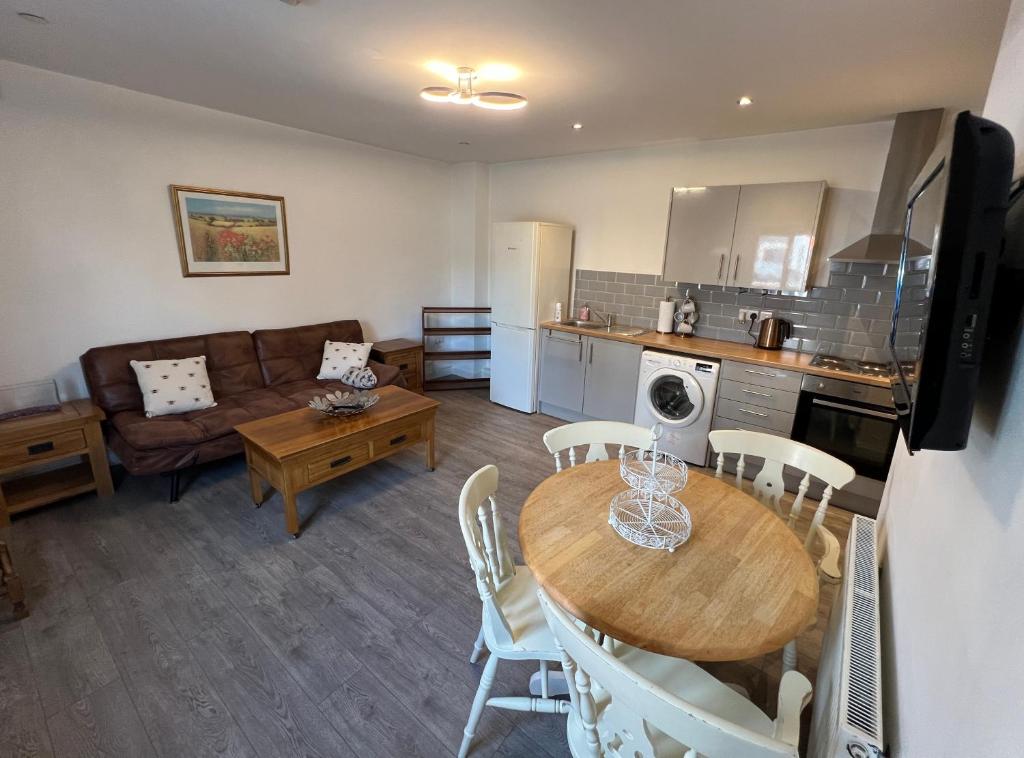 a kitchen and living room with a table and a couch at A spacious flat in Cardiff