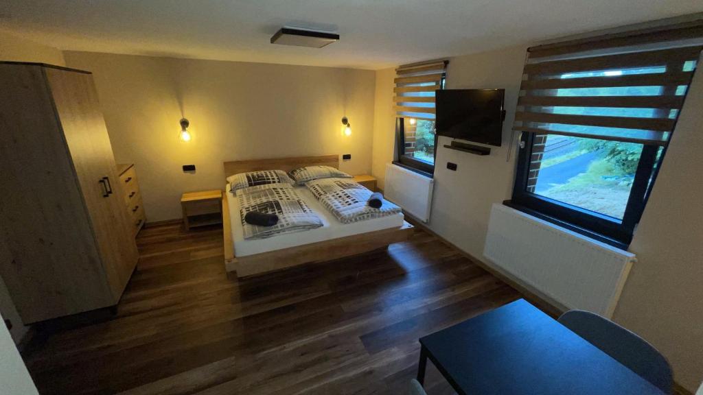 a bedroom with a bed and a tv in it at Penzion Loket in Loket