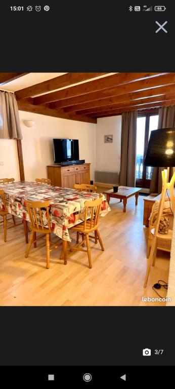 un soggiorno con un grande tavolo e sedie di Appartement T2 Guzet Neige a Ustou