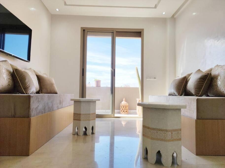 een woonkamer met 2 banken en een groot raam bij Plein centre Marrakech, grand balcon filant in Marrakesh