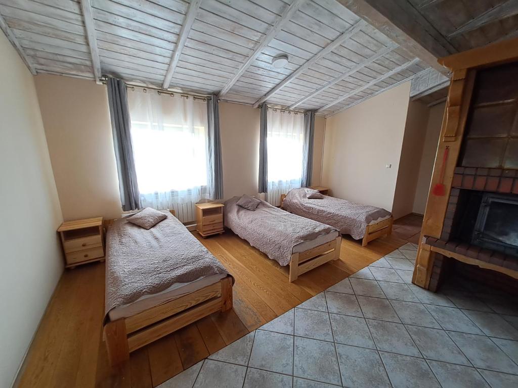 a room with two beds and a fireplace at Akacjowy in Ostrowite
