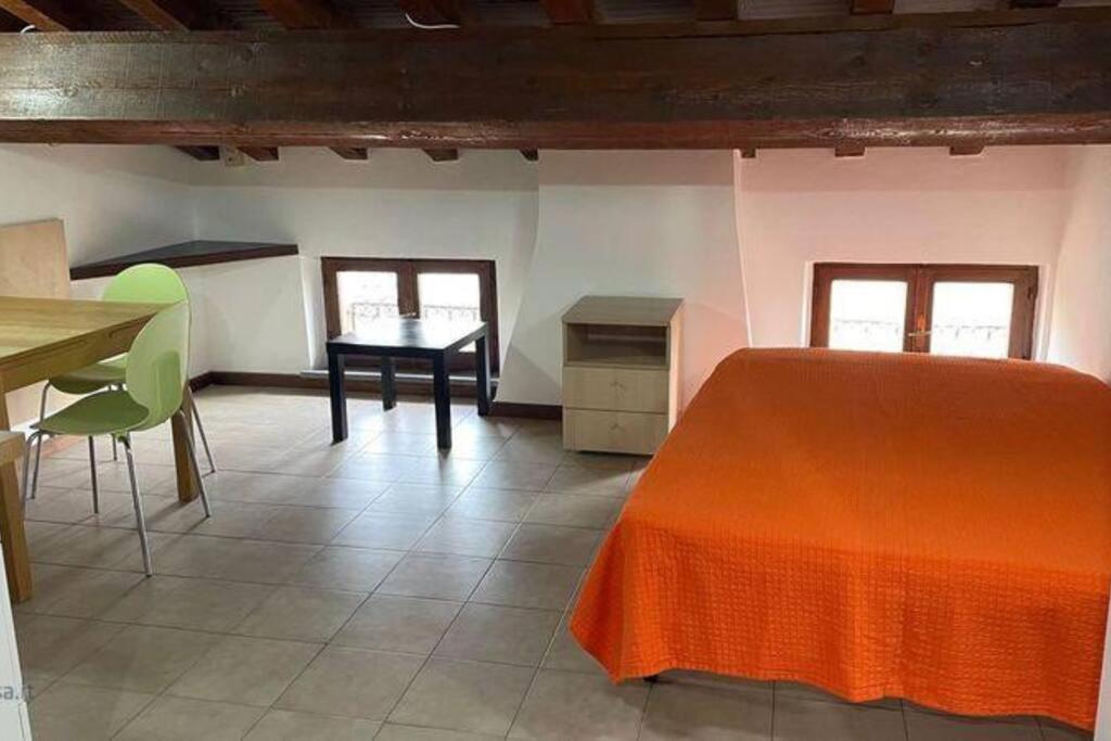 um quarto com uma cama, uma mesa e cadeiras em Monolocale Oltretorrente em Parma
