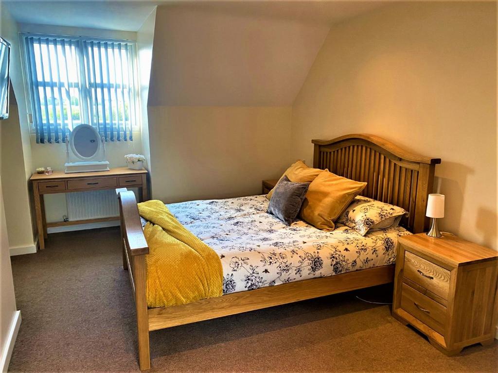 a bedroom with a bed and a table and a television at ThreeStorey Townhouse - Free parking in Normanton