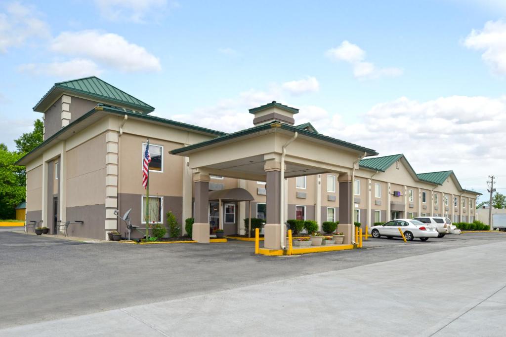 un gran edificio con coches estacionados en un estacionamiento en Country Garden & Suites, en Benton