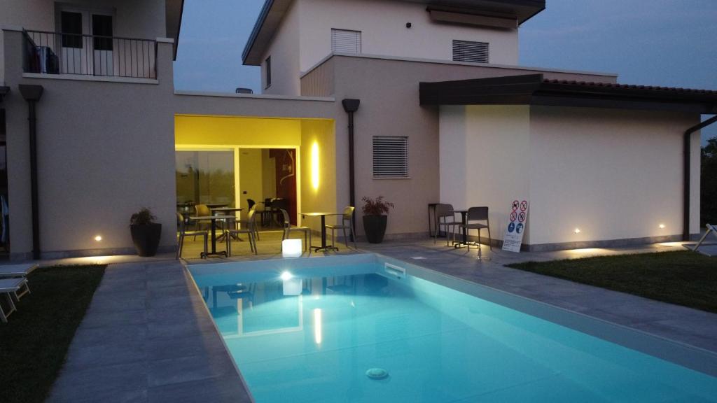 a swimming pool in front of a house at Lough appartamento in Colà di Lazise