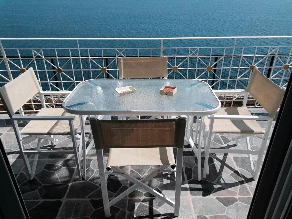 a table and chairs with the ocean in the background at Vila SHAKAJ in Sarandë